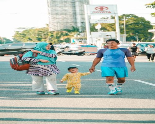 Family taking a light walk in a city park in Indonesia